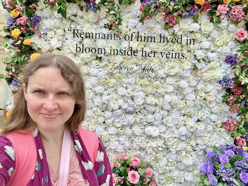 Shannon Kay in front of flower backdrop at yallwest 2024